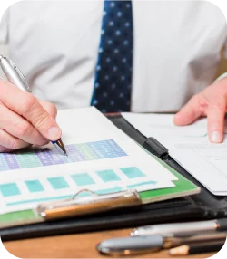 Hombre escribienbdo en hoja con estadisticas